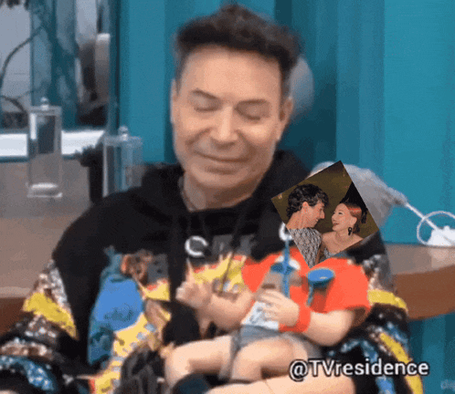 a man is holding a doll with a picture of a man and a woman behind him