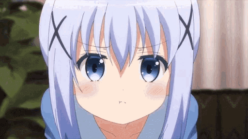 a close up of a girl with blue eyes making a face