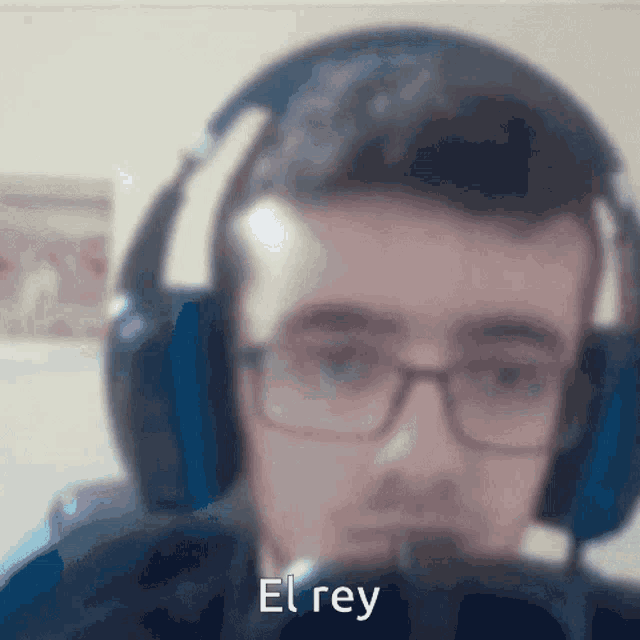a blurry picture of a man wearing headphones with el rey written on the bottom right