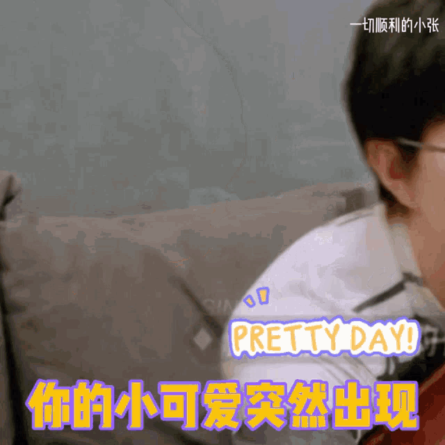 a man is sitting on a couch and says pretty day in a foreign language
