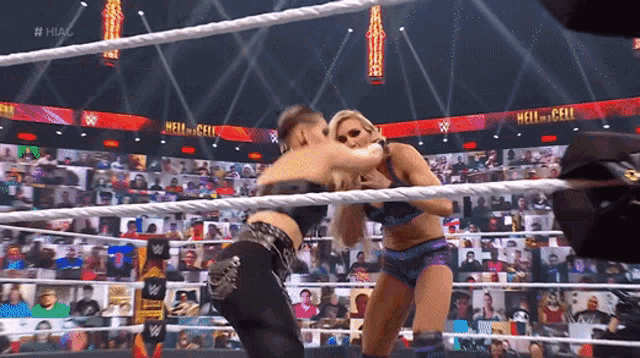 two women are wrestling in a wrestling ring with a crowd watching