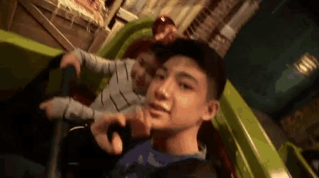 a man and a child are riding a roller coaster at a theme park .