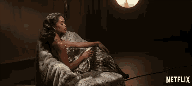a woman is laying on a couch with a netflix logo in the background