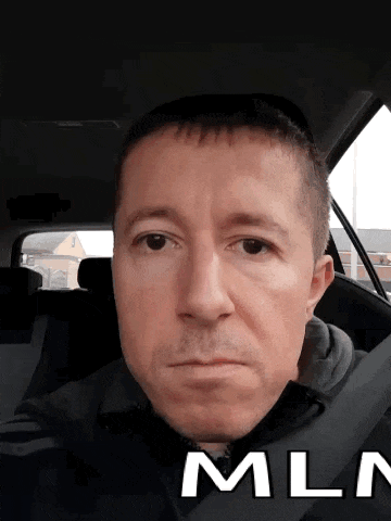 a man in a car with the word mln on the bottom of his face