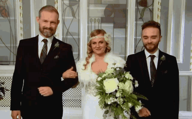 a bride and groom pose for a picture with their parents
