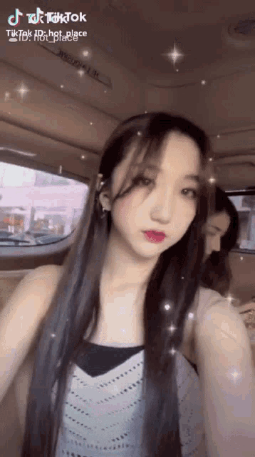 a woman taking a selfie in a car with a tik tok watermark