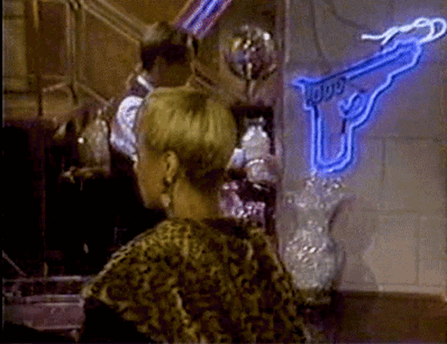 a woman is standing in front of a neon sign that says ' todd ' on it