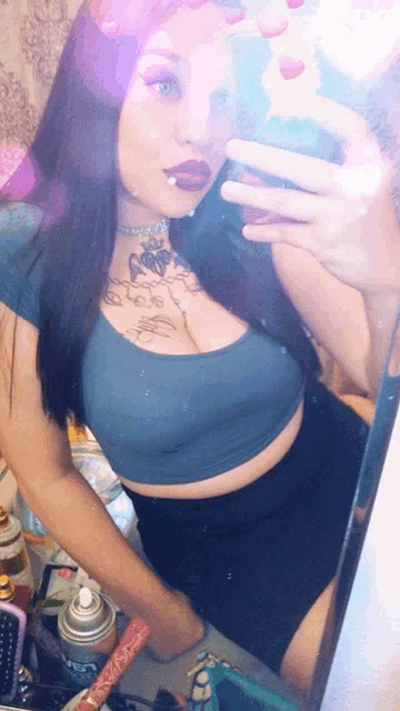 a woman taking a selfie in front of a mirror with a butterfly tattoo on her chest