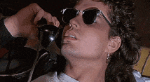 a man wearing sunglasses talking on a phone