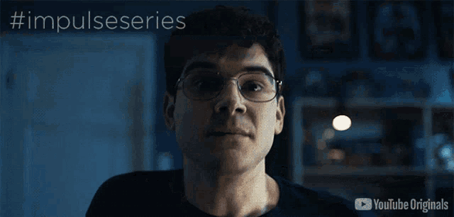 a man in a black shirt is standing in a dark room with the words impulseseries on the bottom