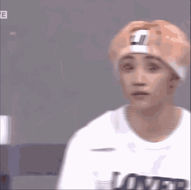 a young man wearing a headband and a t-shirt with the word lover on it
