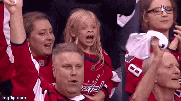 a group of people wearing washington capitals jerseys are watching a game