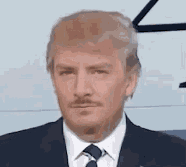 a close up of a man in a suit and tie with a fake donald trump face .