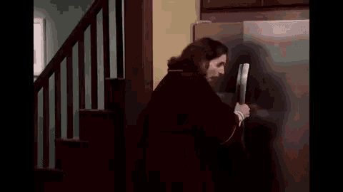 a man is holding a knife in front of a refrigerator .