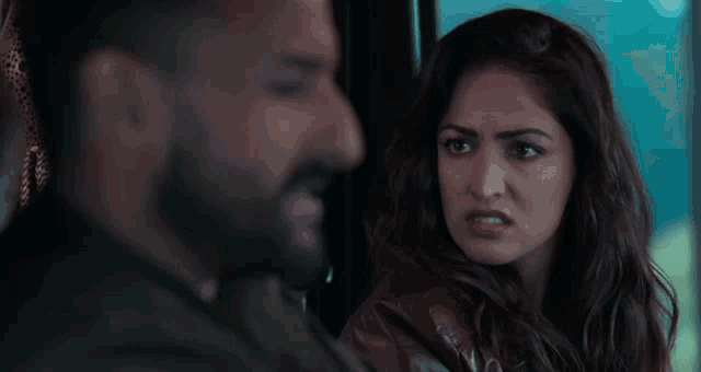 a man and a woman are looking at each other and the woman is making a funny face