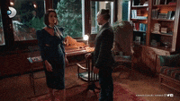 a man and a woman are standing in a living room