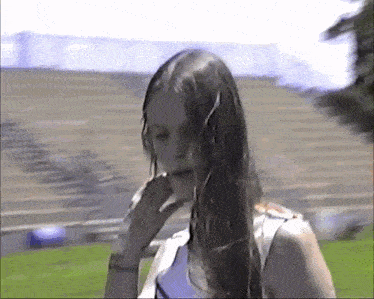 a girl with long hair is standing on a field
