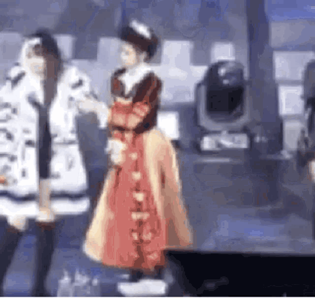 a woman in a red dress is dancing on a stage with another woman .