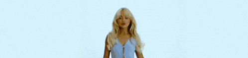a woman with blonde hair is blowing a kiss with her mouth open .