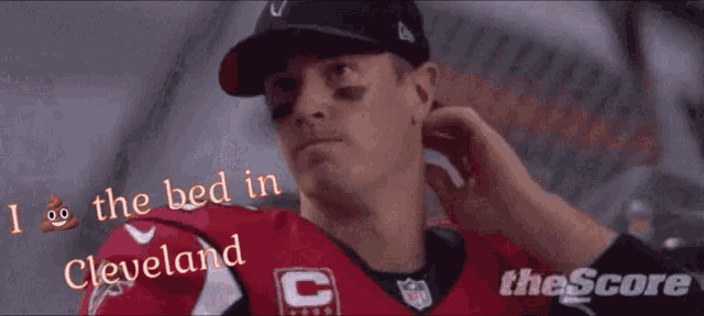 a man wearing a cleveland jersey adjusts his earring