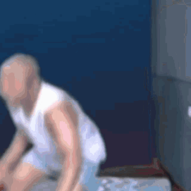 a blurry picture of a man in a white tank top and shorts