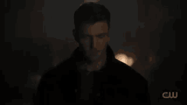 a close up of a man 's face in the dark looking at the camera .