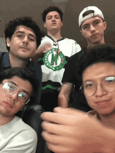 a group of young men are posing for a photo and one of them is wearing a jersey that says boston celtics