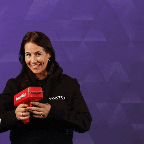 a woman wearing a black voxtur sweatshirt is throwing money in the air