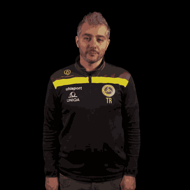 a man wearing a black and yellow shirt with the name tr on it