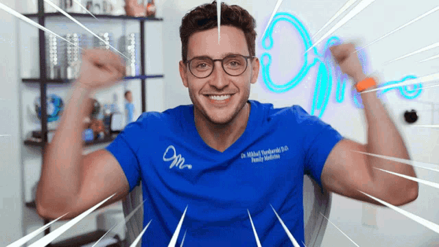 a man wearing glasses and a blue shirt that says dm on it is flexing his muscles