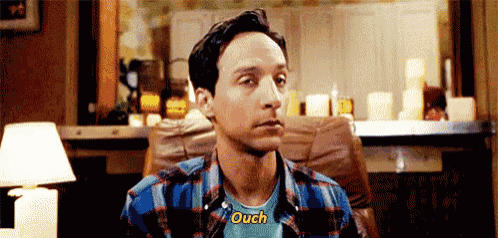 a man in a plaid shirt is sitting in a chair and talking .