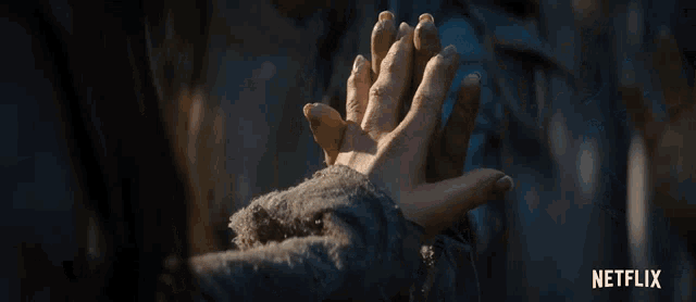a close up of a person holding another person 's hand with a netflix logo in the background