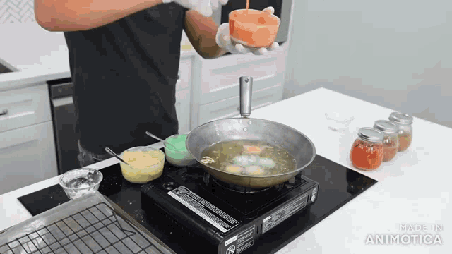 a man is cooking eggs in a frying pan on a stove with the words made in animatica at the bottom