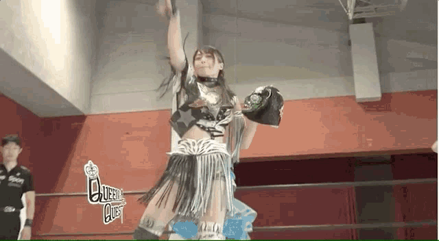 a woman in a wrestling ring with the word queen on the bottom right