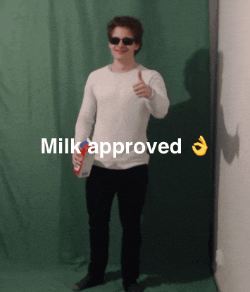 a man giving a thumbs up while holding a carton of milk with the words milk approved below him