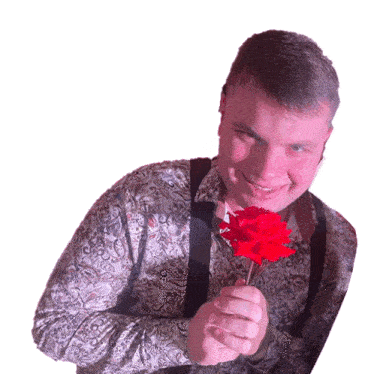 a man in a paisley shirt holds a red rose in his hand