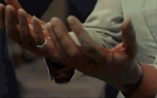 a person 's hands are covered in blood and a ring on their finger .
