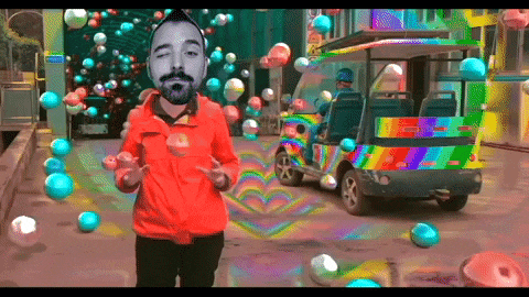a man in a red jacket is standing in front of a colorful vehicle