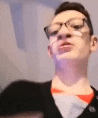 a man with glasses and a bandage on his face is looking at the camera .