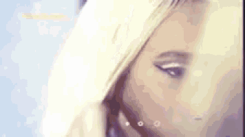 a close up of a woman 's face with blonde hair and white eye makeup .