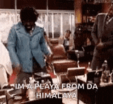 a man in a blue jacket is dancing in a room with a table and chairs .