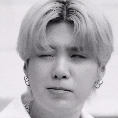 a close up of a person making a funny face with their eyes closed .