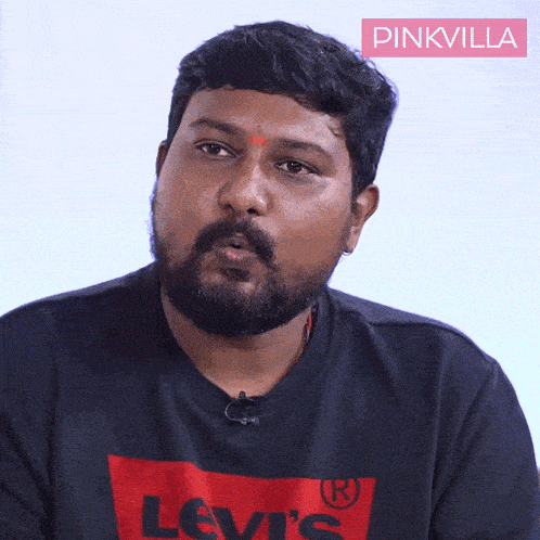 a man with a beard is wearing a black levi 's t-shirt