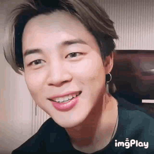 a close up of a person 's face with a smile on their face and earrings .