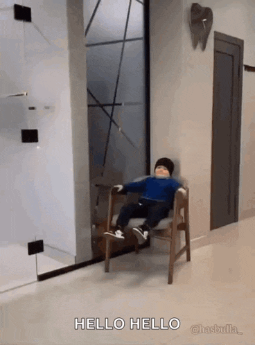 a child is sitting in a chair in a hallway and says hello hello .