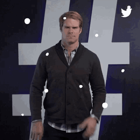 a man standing in front of a hashtag sign