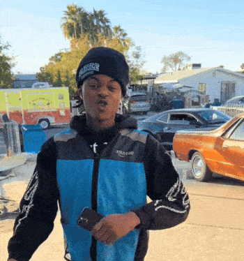 a man wearing a black beanie and a blue jacket with the word amazon on it