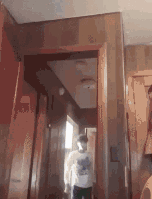 a person in a white shirt is walking through a hallway