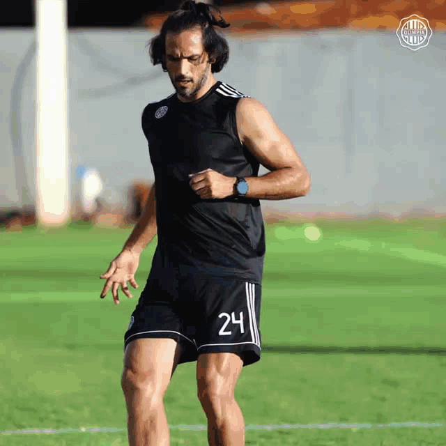 a soccer player with the number 24 on his shorts is running on the field