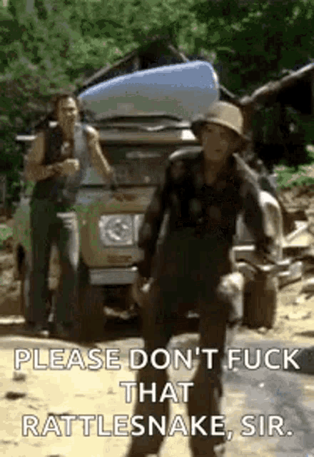 a man in a hat is standing in front of a truck with a canoe on the back .